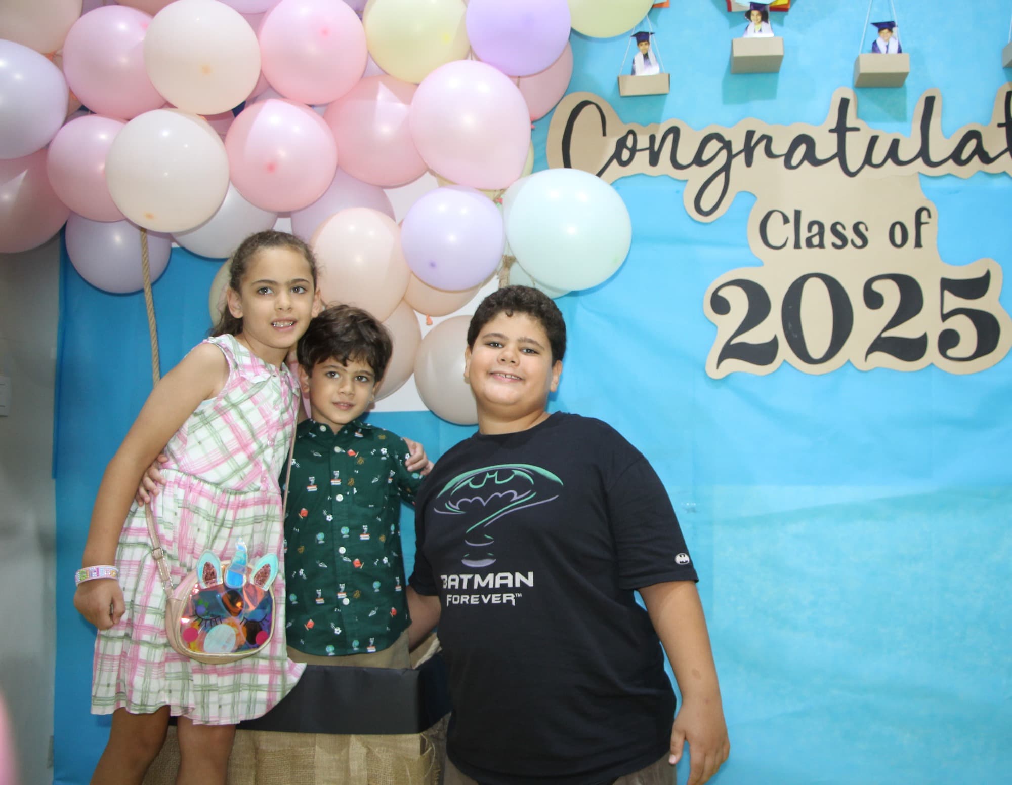 A Super Kidz graduate celebrating in cap and gown
