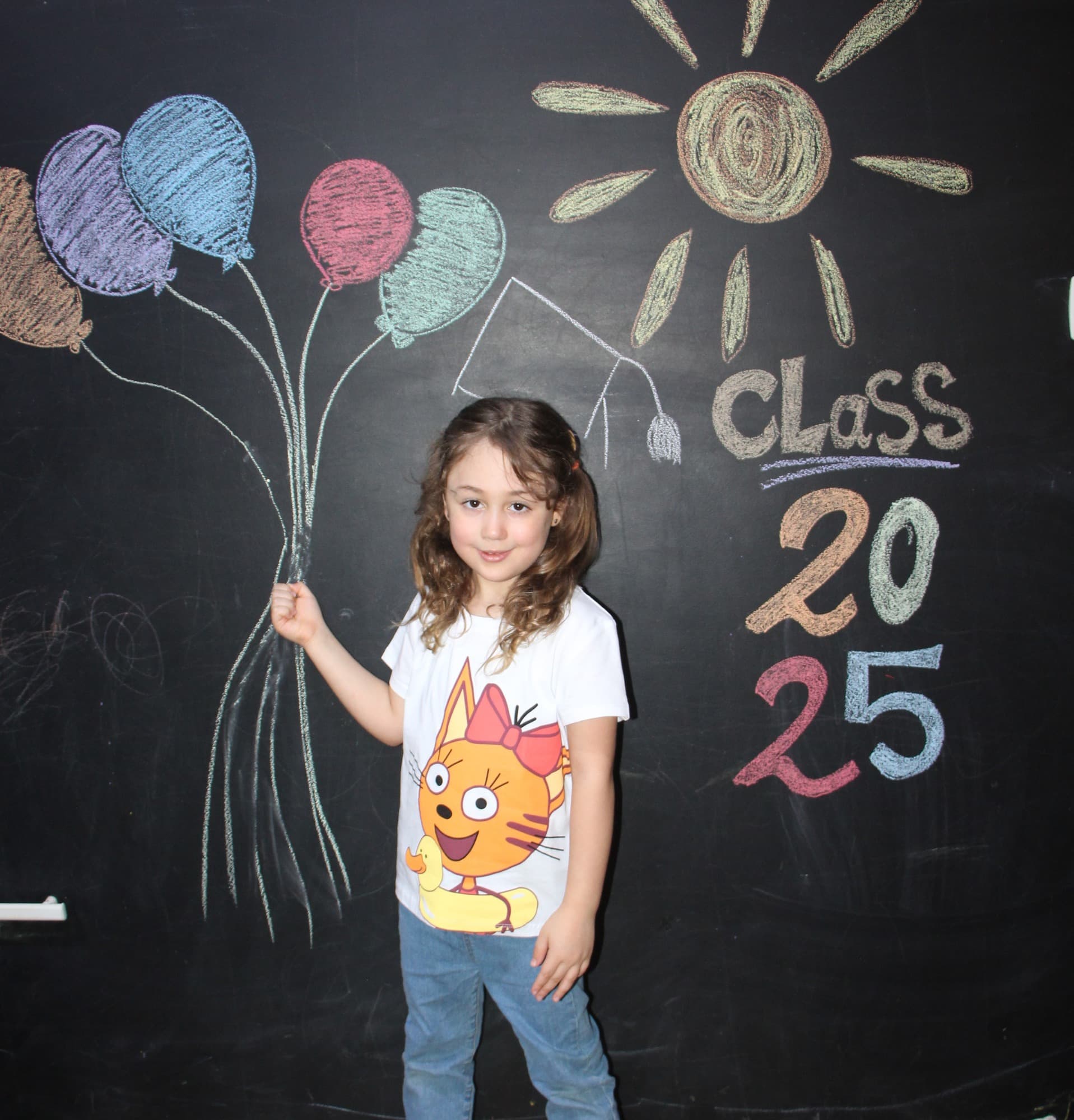 A Super Kidz graduate celebrating in cap and gown