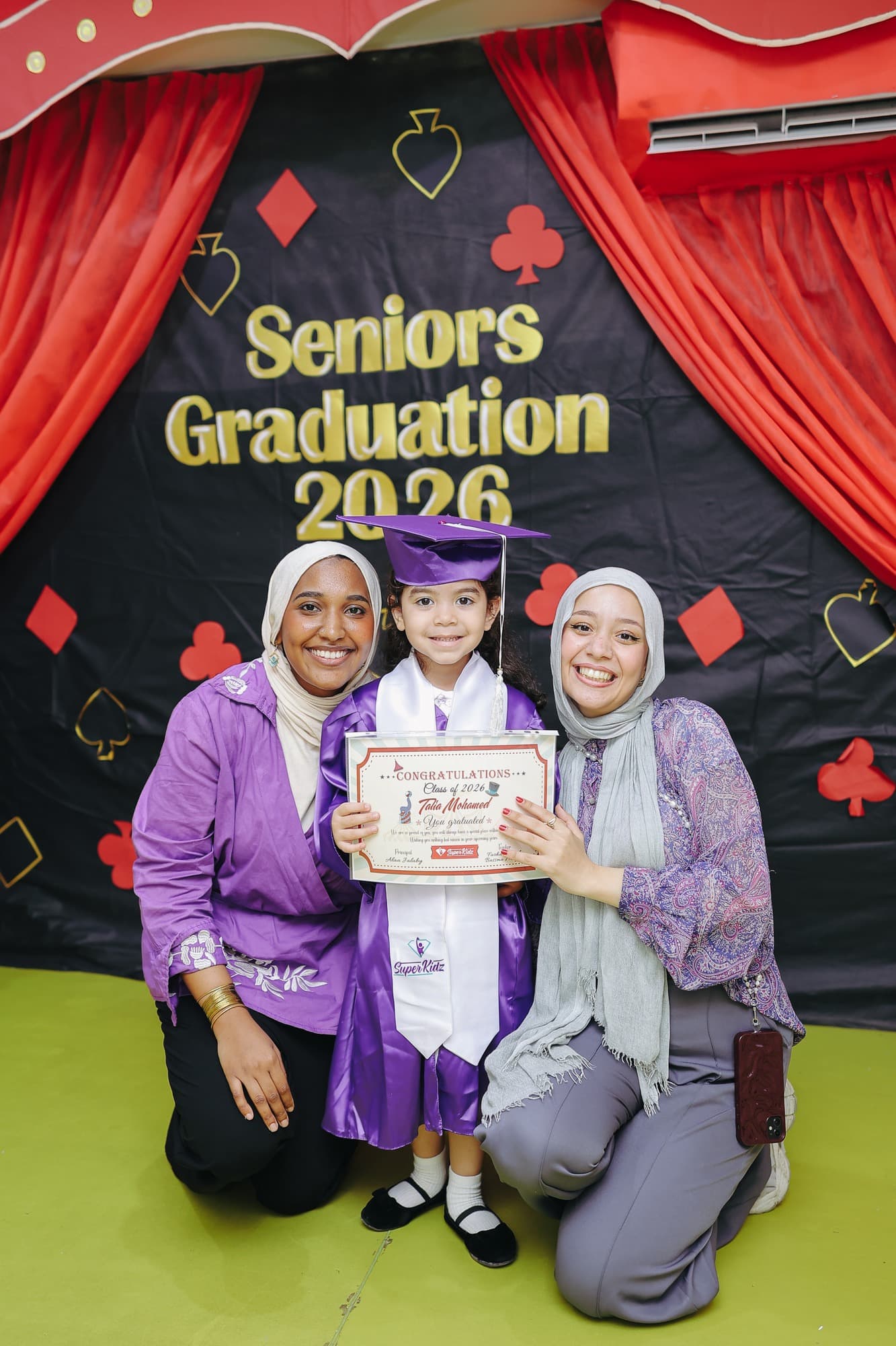 A Super Kidz graduate celebrating in cap and gown