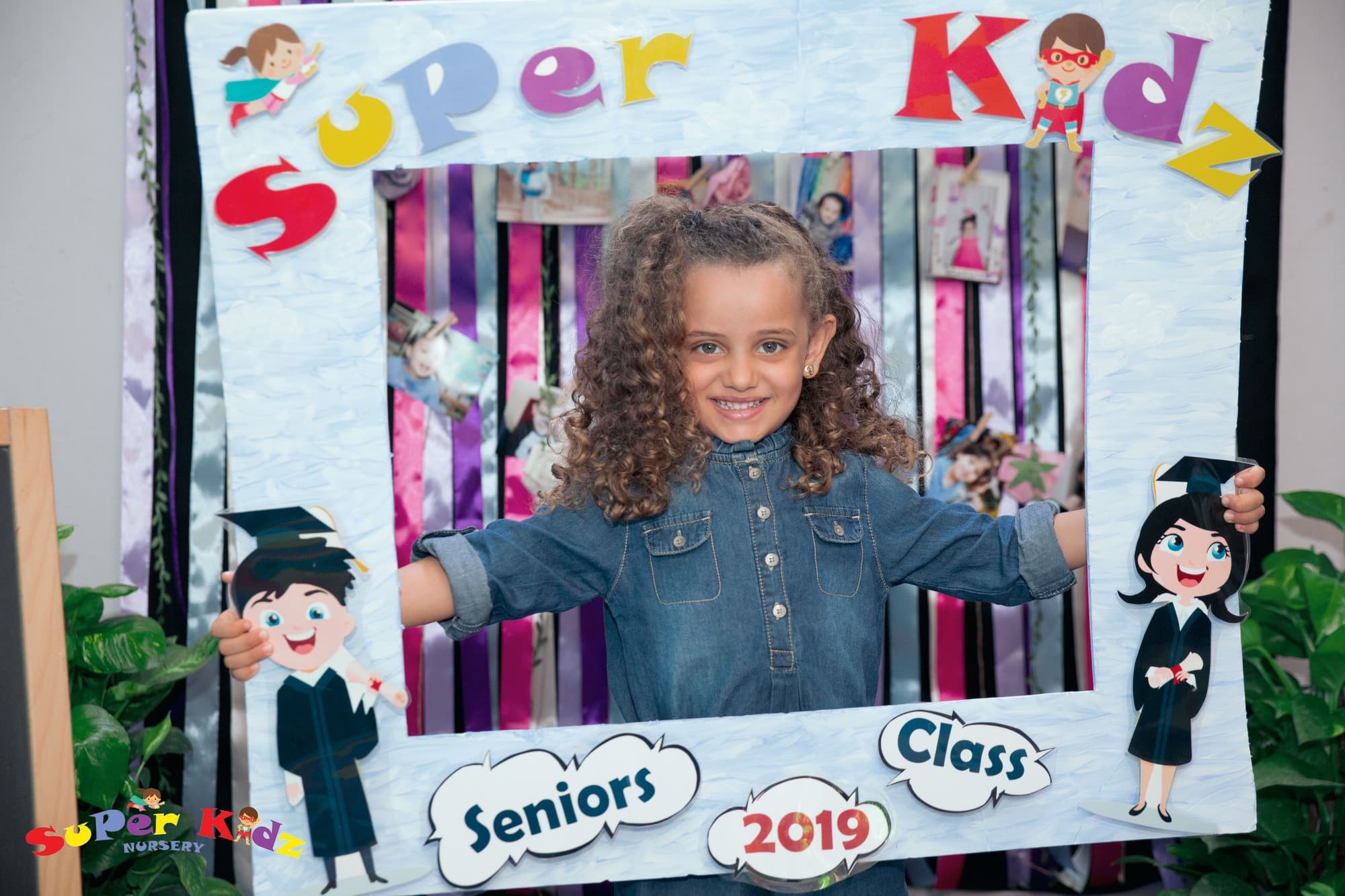 A Super Kidz graduate celebrating in cap and gown