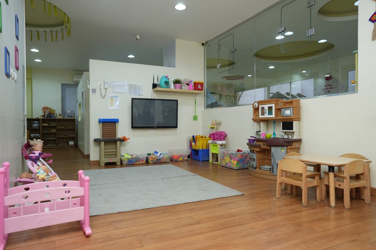 The pretending corner with a play kitchen, workbench, doll’s cot and low tables
