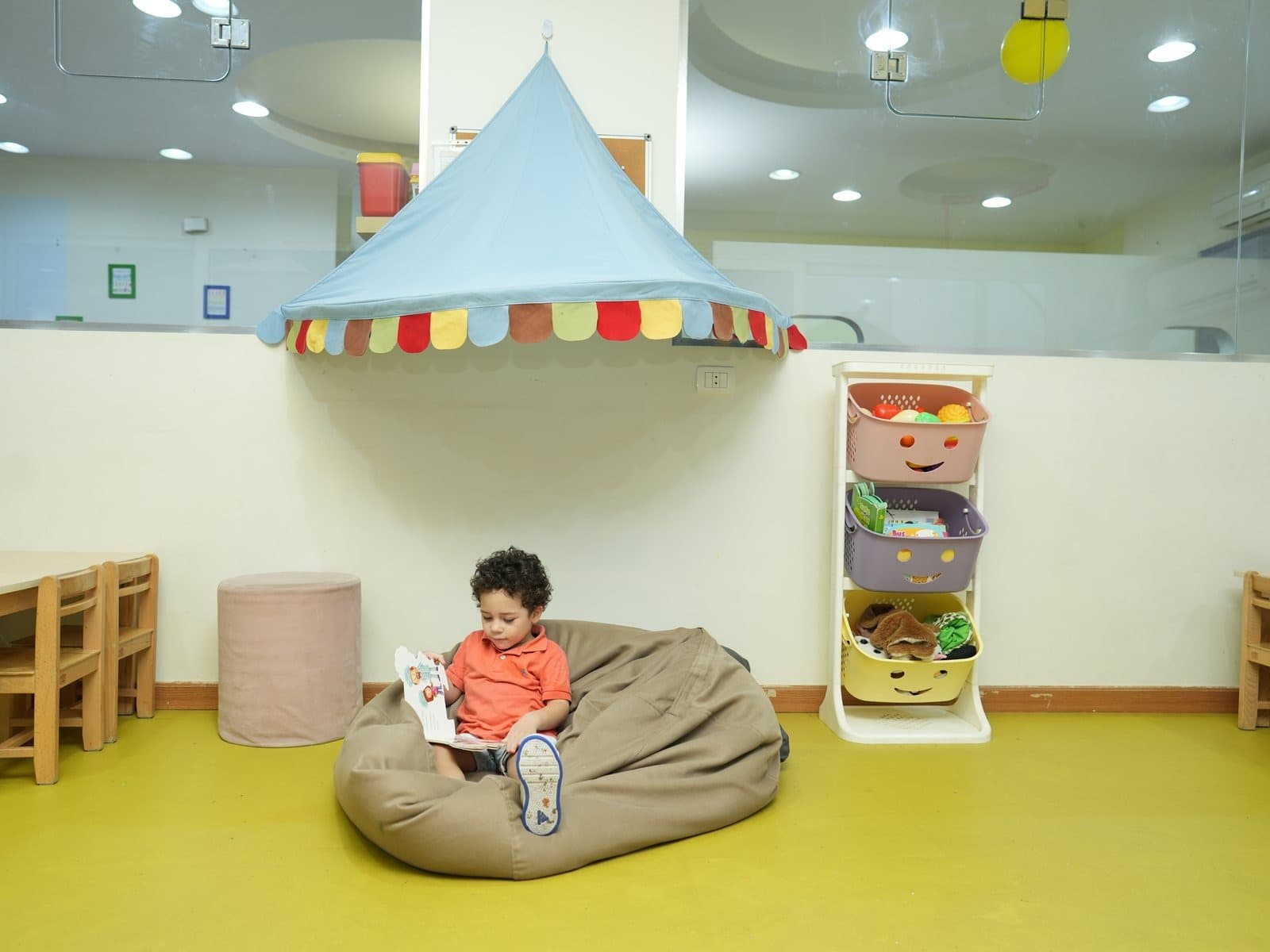 A child reading in a beanbag under the canopy in the reading corner