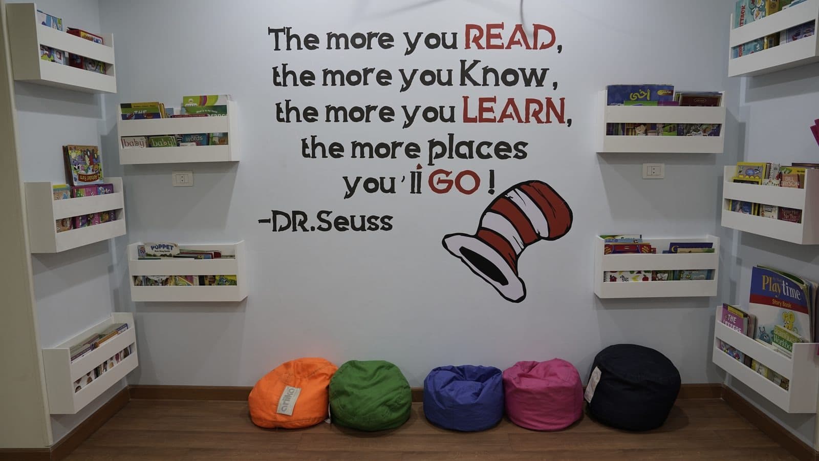 The reading corner: wall-mounted book shelves, beanbags and a Dr. Seuss reading quote