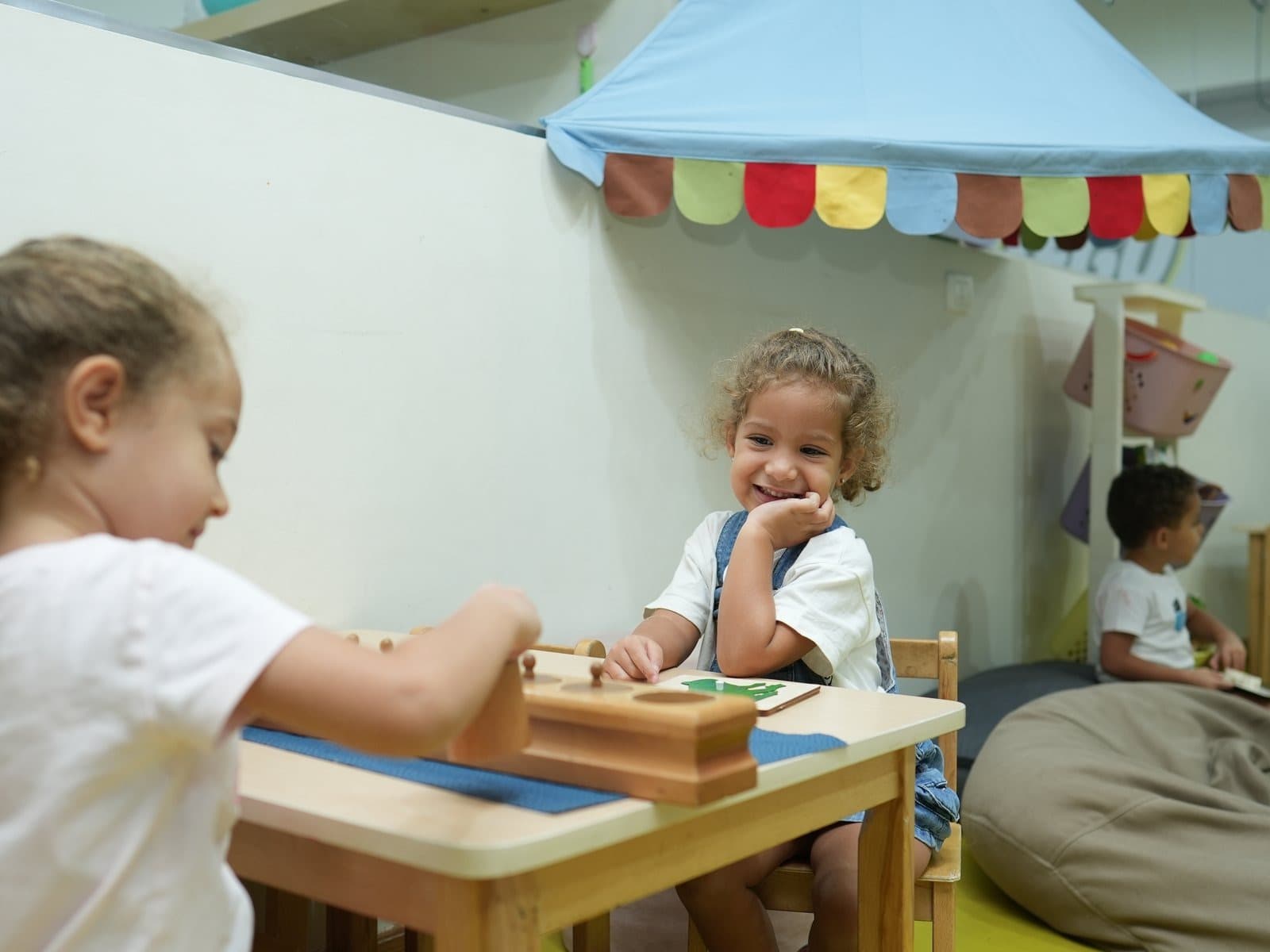 Two children working with wooden Montessori materials at a table