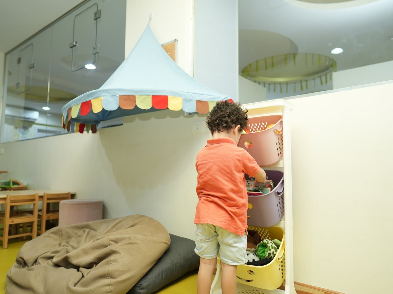 A child choosing a book from the baskets under the reading canopy