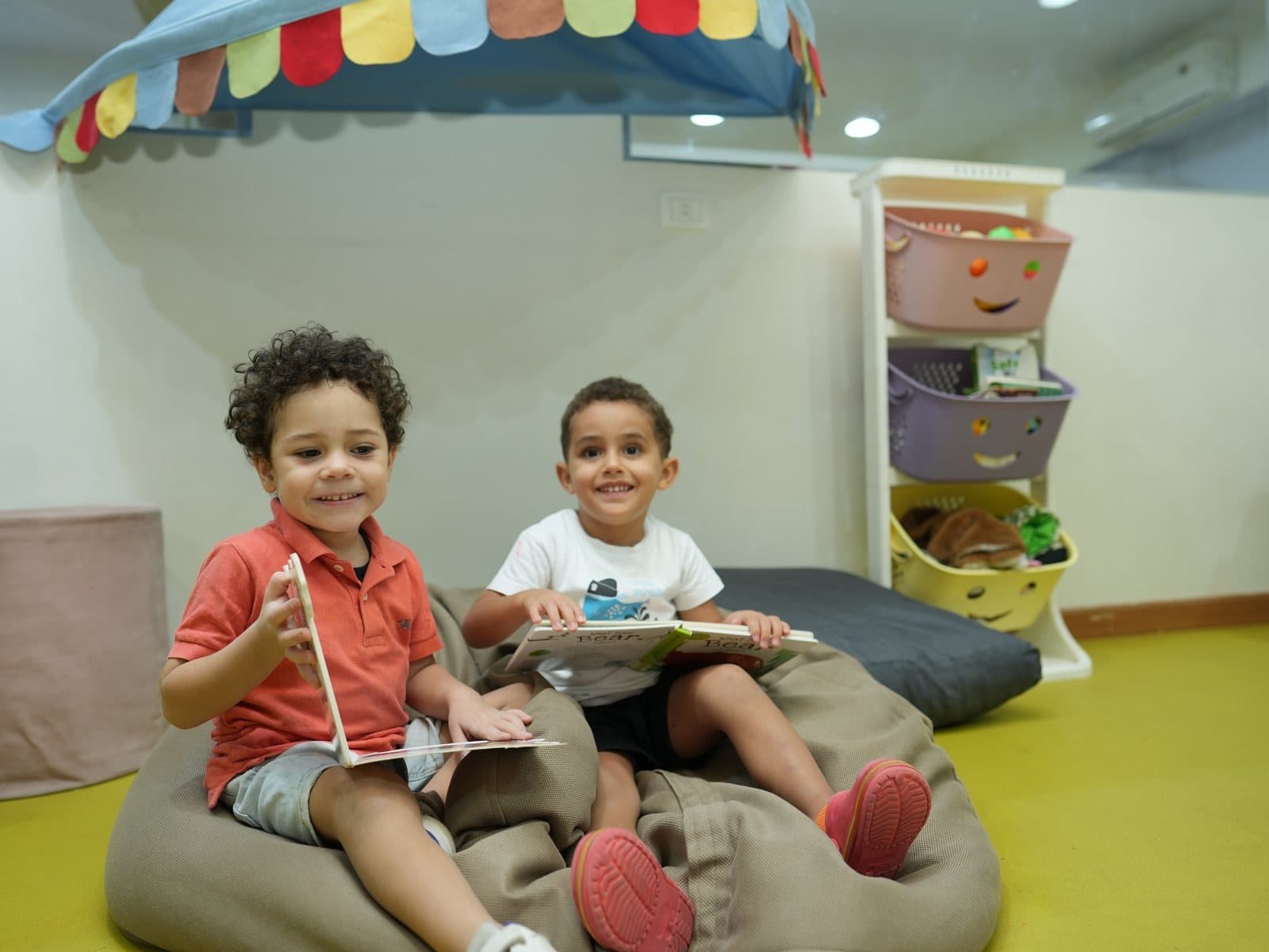 Two children reading together on the beanbags