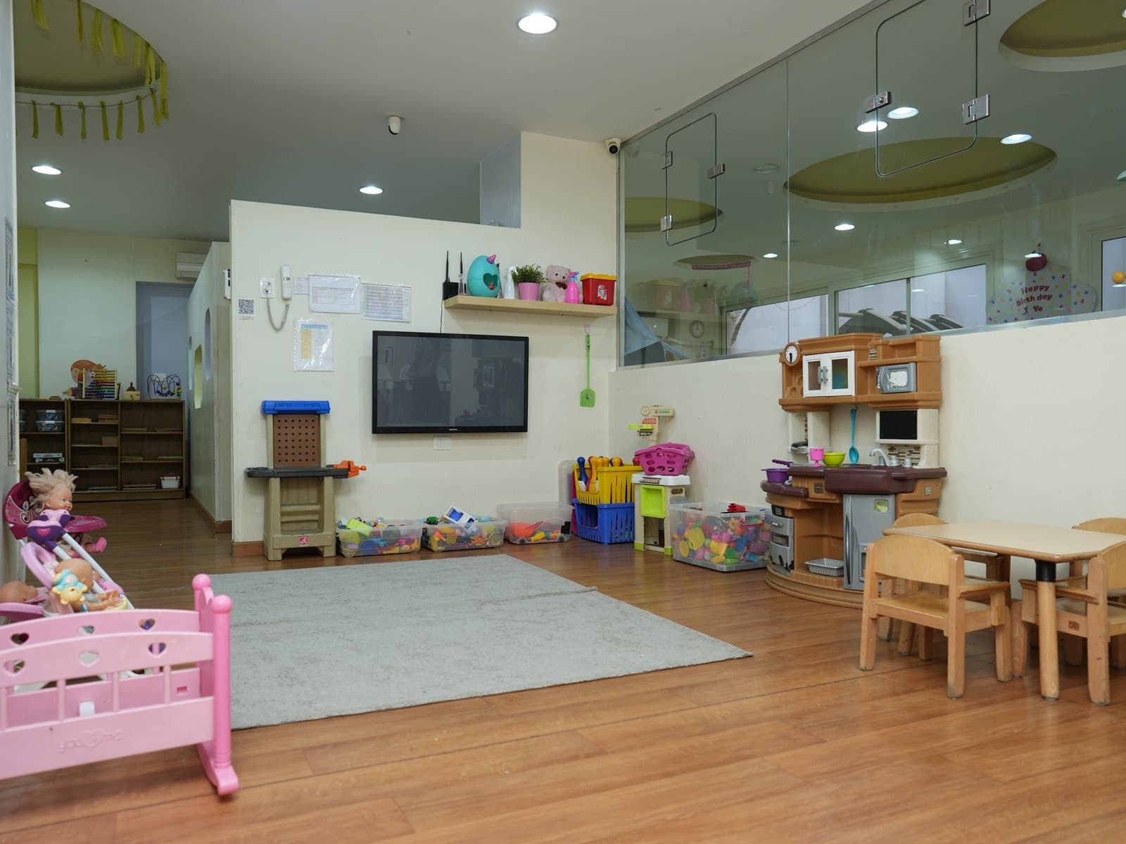 The pretending corner where the toddlers play, with a doll’s bed and low tables